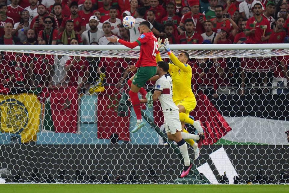 摩洛哥前鋒恩內西里(紅衣)在葡萄牙門將面前頂進致勝球。（美聯社資料照）