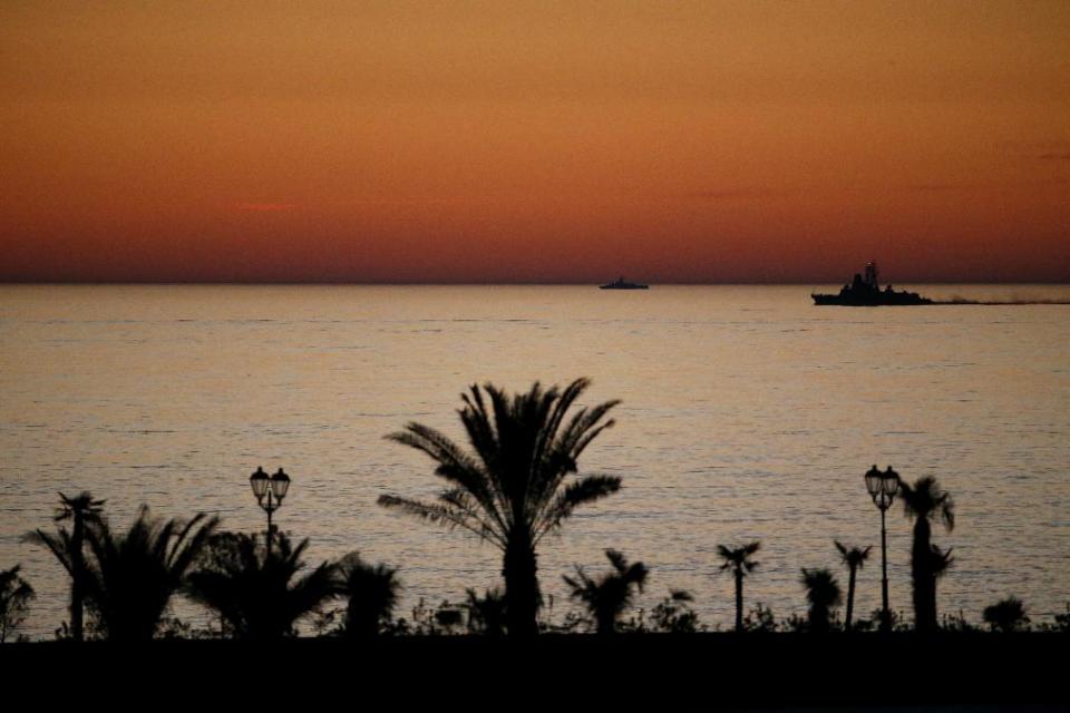 In this Wednesday, Feb. 12, 2014, photo, two small ships cruise along the Black Sea as the sun sets seen from the Bolshoy Ice Dome at the 2014 Winter Olympics, in Sochi, Russia. (AP Photo/Julio Cortez)