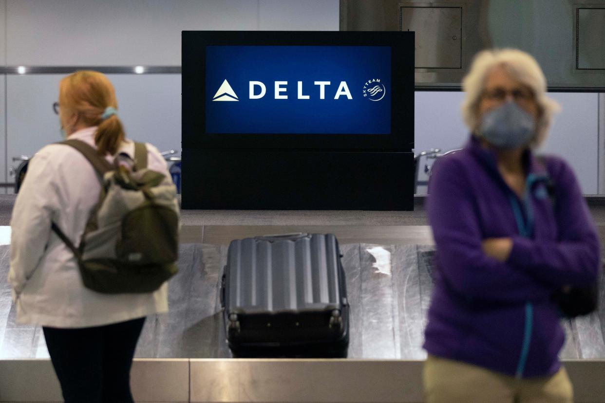 Passengers wait for luggage in the arrival area of Delta Air Lines at Logan International Airport in Boston. 