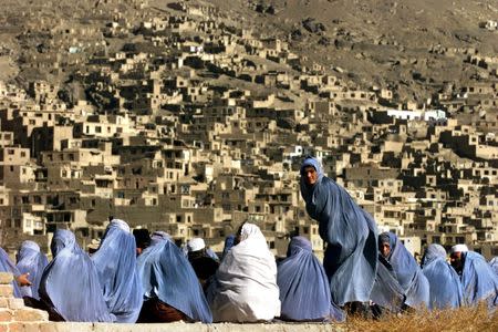 Afghan women wait for distribution of humanitarian aid in Kabul December 4, 2001. REUTERS/Damir Sagolj/Files