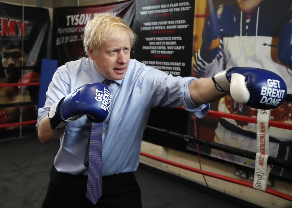 FILE - In this Tuesday, Nov. 19, 2019 file photo Britain's Prime Minister Boris Johnson poses for a photo wearing boxing gloves during a stop in his General Election Campaign trail at Jimmy Egan's Boxing Academy in Manchester, England. (AP Photo/Frank Augstein, File)