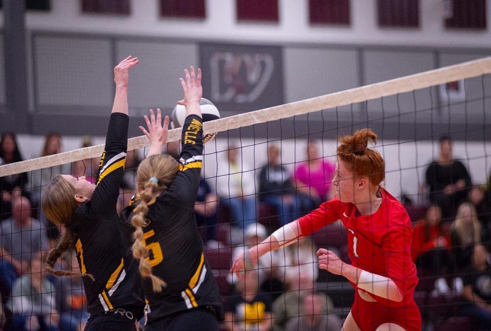 Buckeye Central's Mia McDougal smashes the ball into the Monroeville block of Alexa and Ady Adams