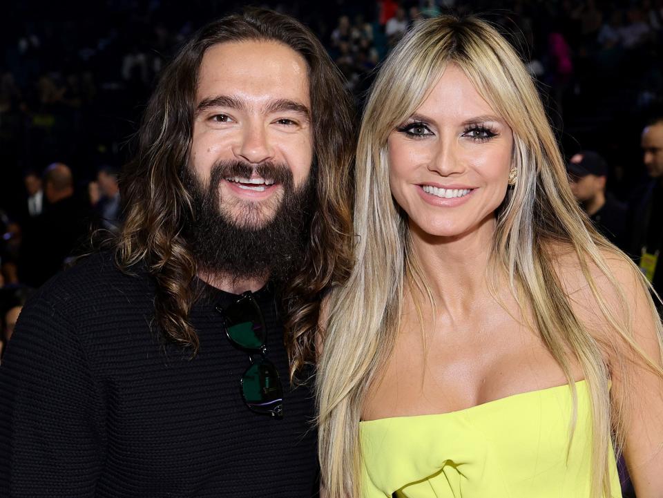 Tom Kaulitz poses with Heidi Klum, in a lime green dress, at the 2022 Billboard Music Awards.