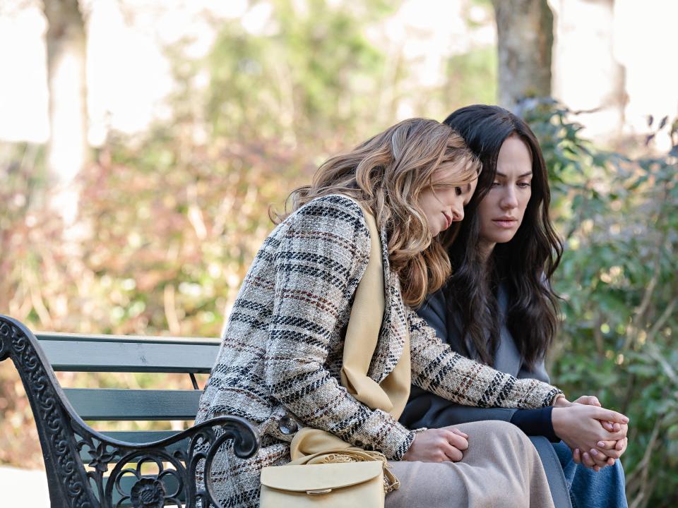 Lucie Guest as Gina and Kate Siegel as Jenn sitting on a bench in Netflix's "Hypnotic."