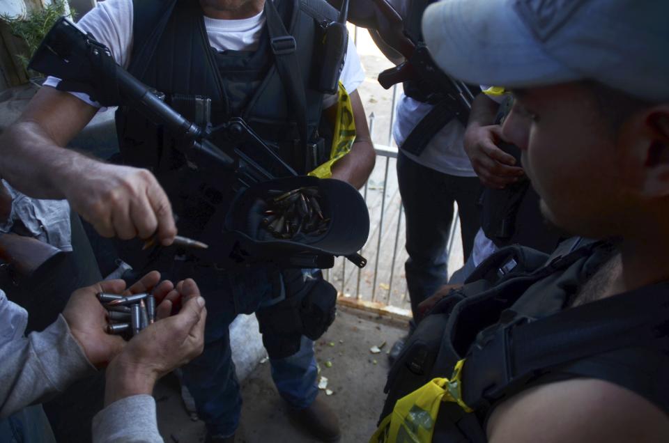 Members of the community police, acting in this case as vigilantes, hold bullets on a highway near the village of Paracuaro