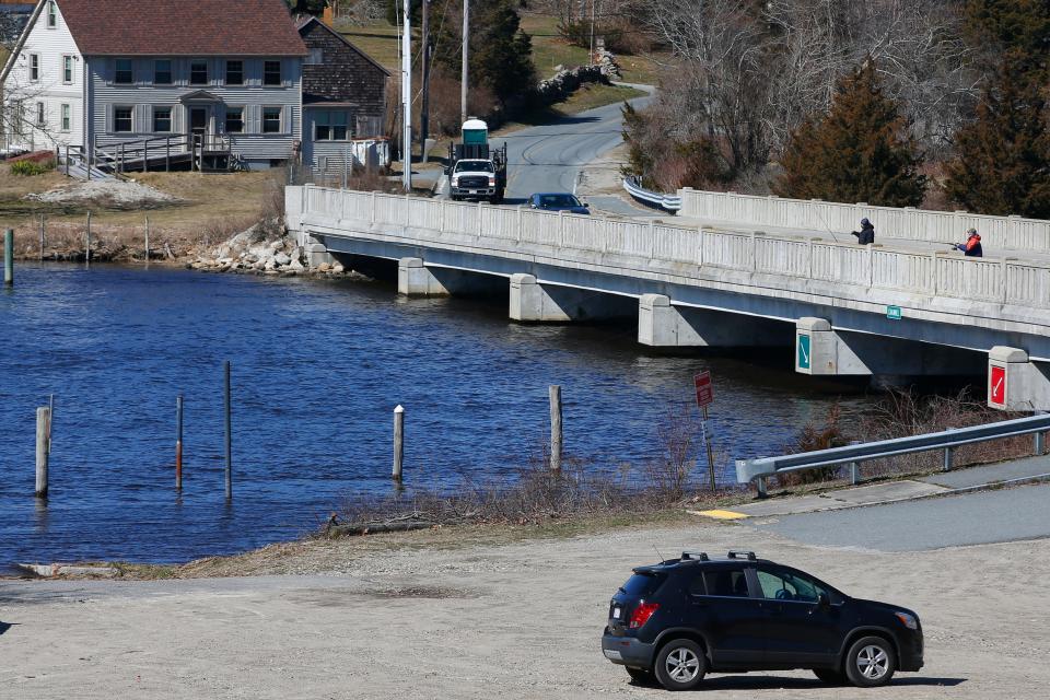 Two men fish from Hix bridge in Westport, in the foreground the boat ramp and broken dock piles which residents want replaced.