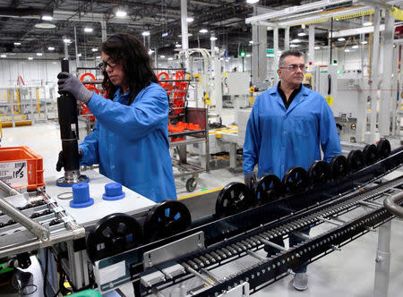 General Motors production workers Dina Mays and Joseph Stanton work on the 10-speed transmission assembly at the General Motors (GM) Powertrain Transmission plant in Toledo, Ohio, U.S., March 6, 2019. REUTERS/Rebecca Cook/Files