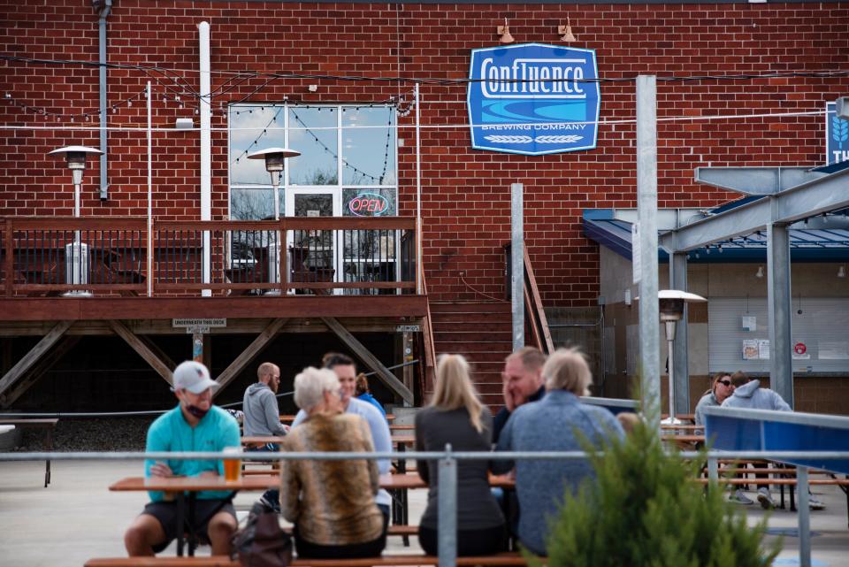 Patrons enjoy outdoor food and drinks at Confluence Brewing in Des Moines.