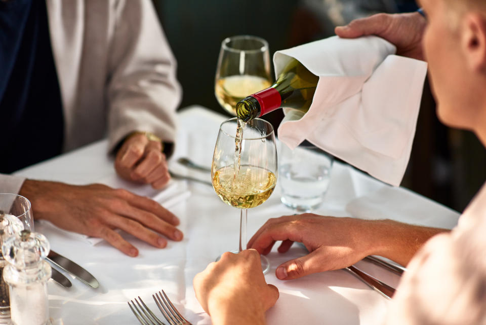 Wine glasses being refilled inside a restaurant