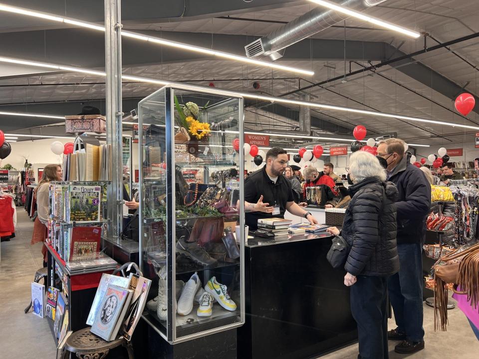 Employees help customers check out shortly after the grand opening of the Cottage Grove St. Vincent de Paul retail location on Thursday morning.