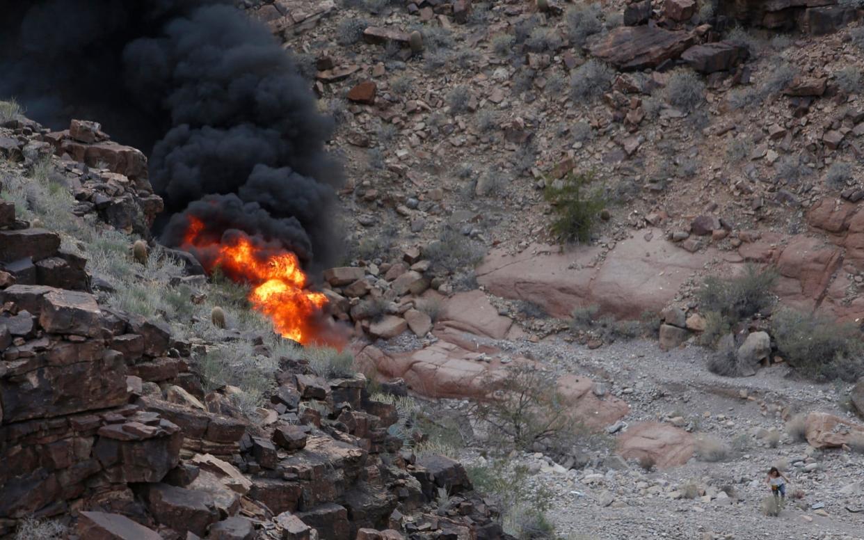 A survivor (lower right) walks away from the scene of the crash - Teddy Fujimoto