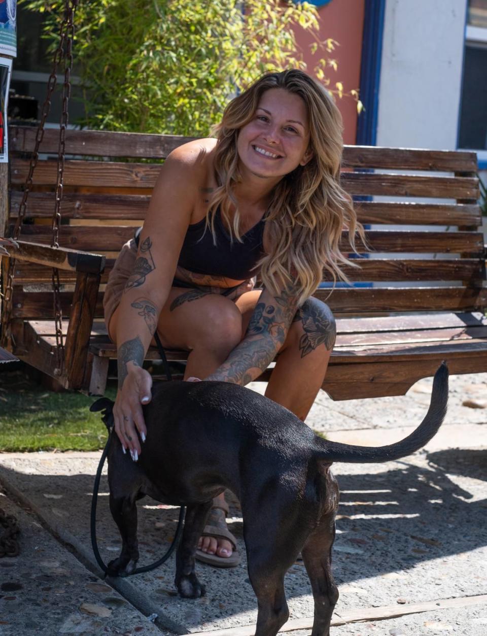 Former Cal Fire employee Carrie Young, seen here with her dog Mary J. in Cayucos on Sept. 21, 2023, settled a lawsuit with Cal Fire after she was sexually assaulted by James Thomas, a coworker, in 2020. Thomas was convicted of sexual battery in relation to the incident in May 2023.