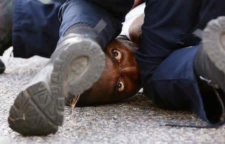 A man protesting the shooting death of Alton Sterling is detained by law enforcement near the headquarters of the Baton Rouge Police Department in Baton Rouge, Louisiana, U.S. July 9, 2016. REUTERS/Jonathan Bachman