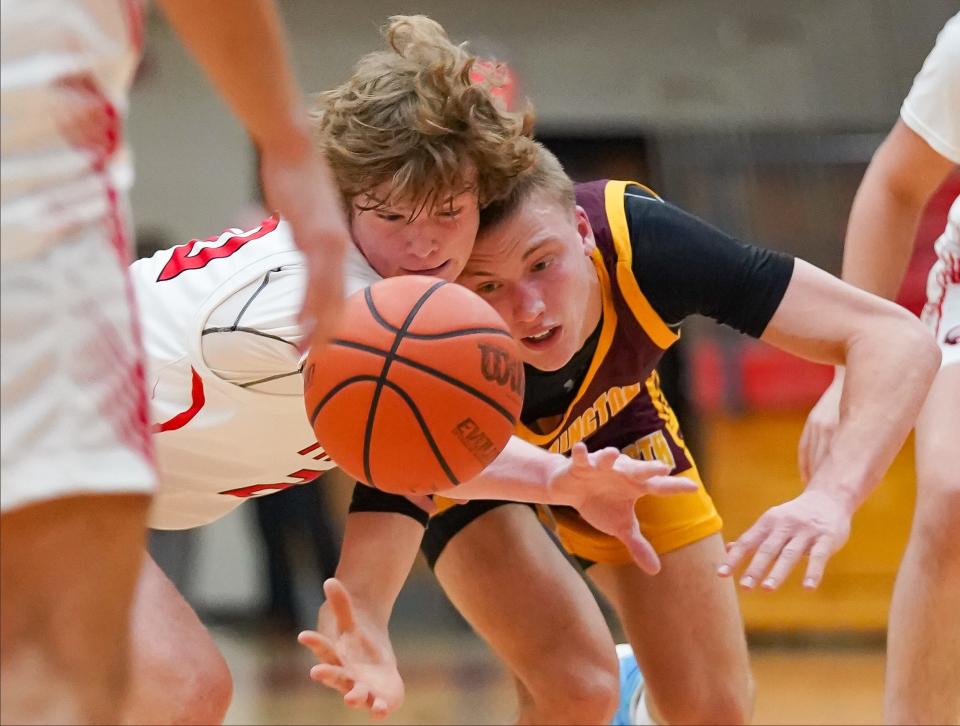 Center Grove’s Gabe Baxter (20) and Bloomington North’s Luke Lindeman (22) chase after a loose ball during their game at Center Grove on Friday, Dec. 1, 2023.