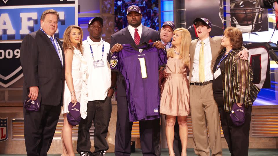 Michael Oher posed with the Tuohy family and others when he was drafted by the Baltimore Ravens in the first round of the 2009 NFL Draft. - David Bergman/Sports Illustrated/Getty Images