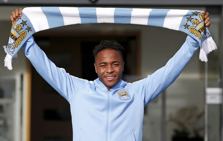 New Manchester City signing Raheem Sterling poses with a club scarf as he leaves the club's Etihad Stadium in Manchester, Britain, July 14, 2015. REUTERS/Andrew Yates