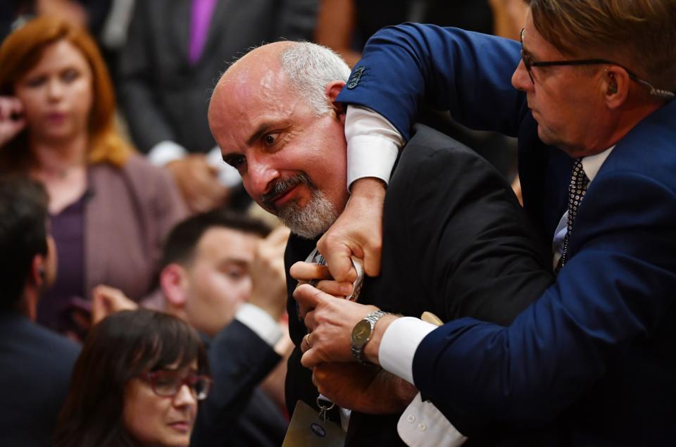 <span class="s1">Sam Husseini is escorted out of the press conference room at the Presidential Palace in Helsinki. (Photo: Yuri Kadobnov/AFP/Getty Images)</span>