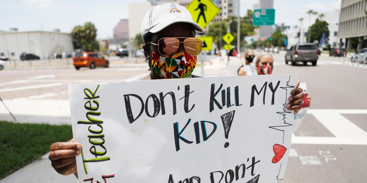 Business education teacher Malikah Armbrister stands in protest along with her colleagues in front of the Hillsborough County Schools District Office on July 16, 2020 in Tampa, Florida.