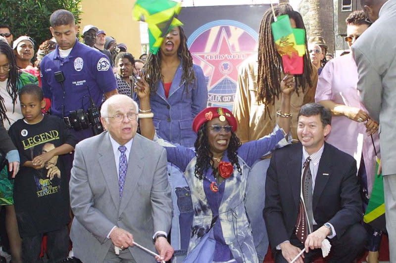 Johnny Grant (L) and Leron Gubler present Rita Marley and her children with a star for the late Bob Marley in Hollywood in 2001. File Photo by Russ Einhorn/UPI