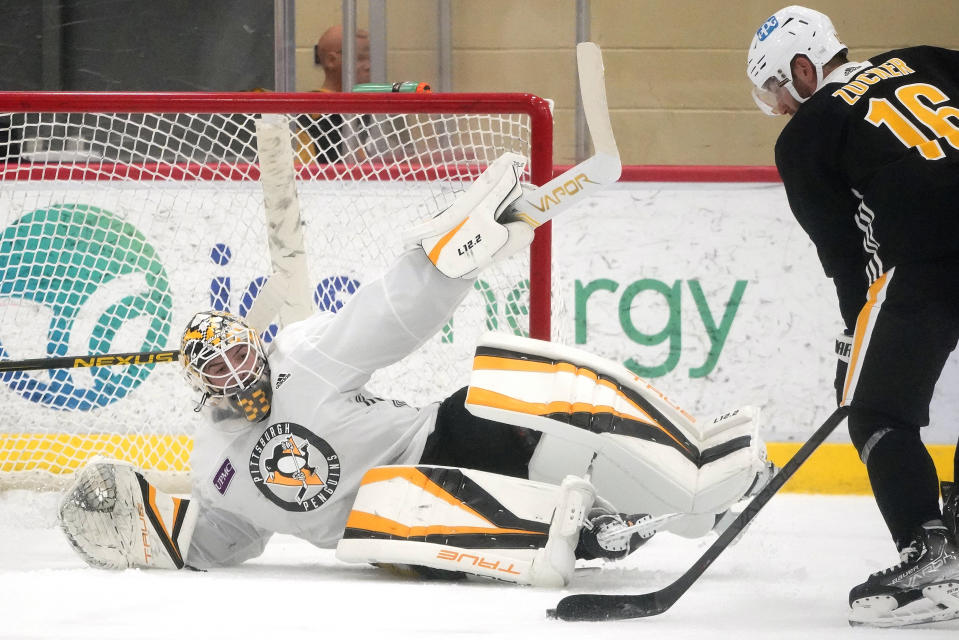 Pittsburgh Penguins goalie Alex D'Orio attempts to block a shot by Jason Zucker (16) during the team's first NHL hockey practice of the season in Cranberry, Pa., Thursday, Sept. 23, 2021. (AP Photo/Gene J. Puskar)