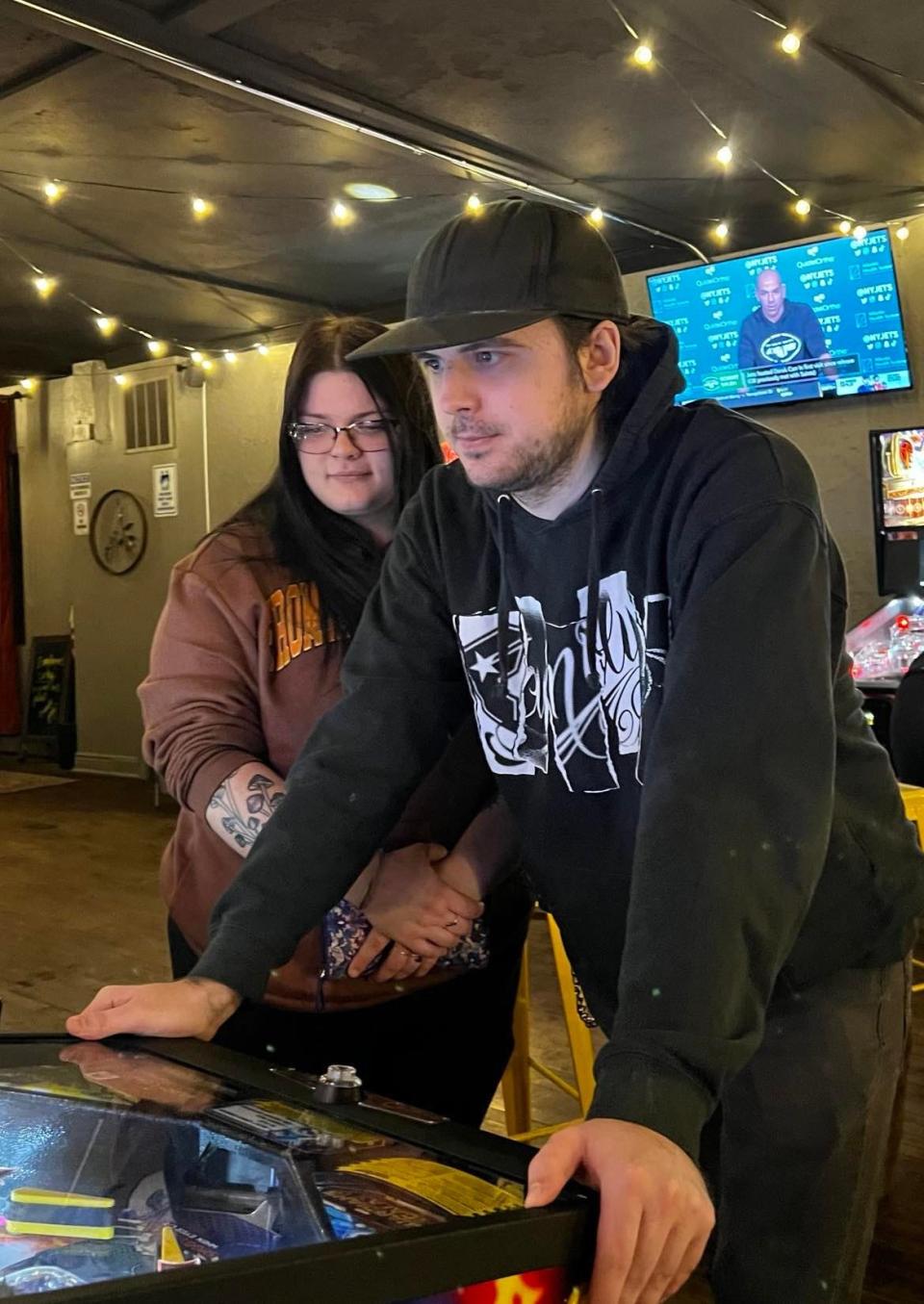 Joseph Vuoso, 23, of Malvern, plays pinball at the Sandy Springs Brewery arcade while Kaylee Catalano watches.