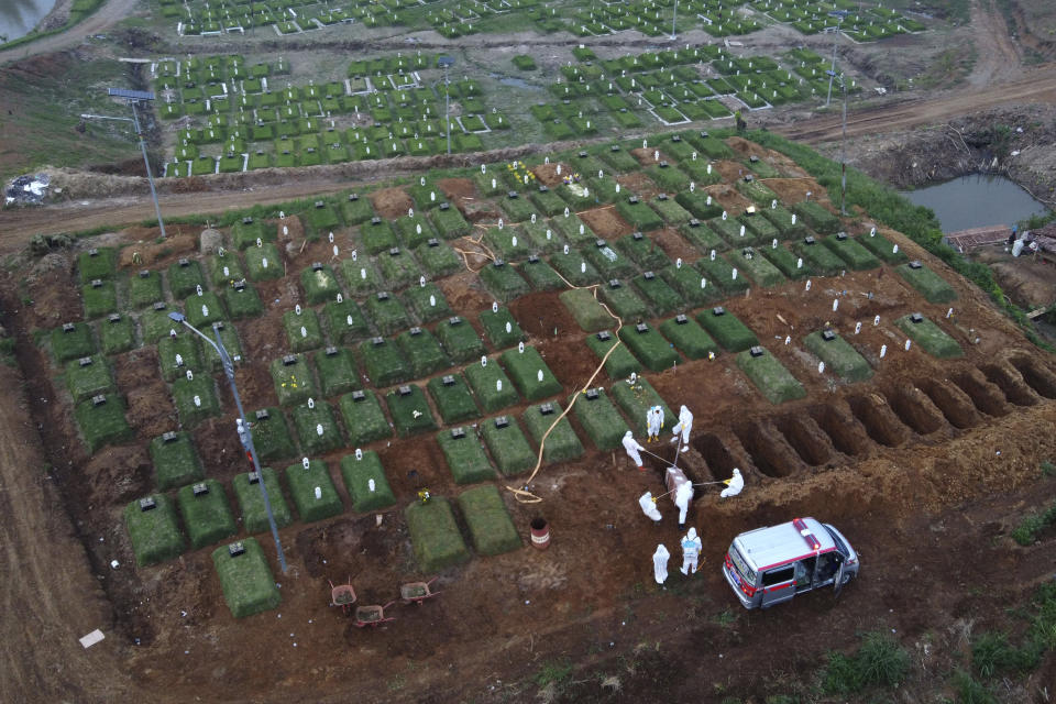 This aerial shot shows workers bury a COVID-19 victim in Medan, North Sumatra, Indonesia, Thursday, July 1, 2021. After a slow vaccination rollout, Indonesia is now racing to inoculate as many people as possible as it battles an explosion of cases that have overburdened its health care system. (AP Photo/Binsar Bakkara)