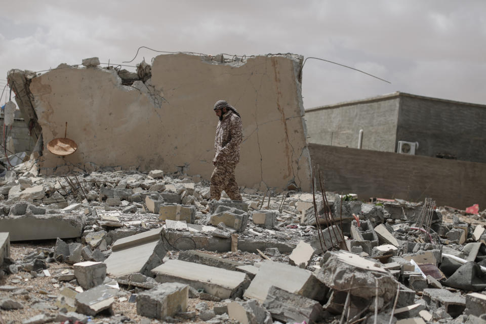 A soldier loyal to the 'Libyan Dawn' movement looks at damage caused by an air strike at a house in Bin Jawad, the last town before the frontline near Sidra, a key oil terminal in Libya than is currently contested by the country's two opposing governments, on March 7, 2015. (Photo: Sam Tarling/Corbis via Getty Images)