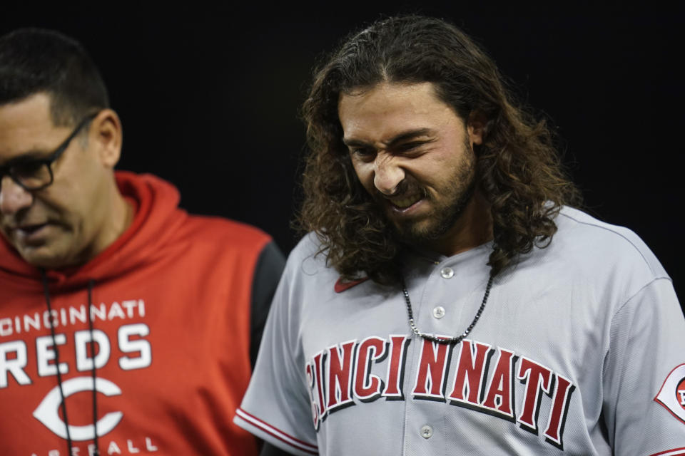 Cincinnati Reds' Jonathan India reacts as he's taken off the field for injury after reaching first base during the fifth inning of a baseball game against the Los Angeles Dodgers in Los Angeles, Thursday, April 14, 2022. (AP Photo/Ashley Landis)