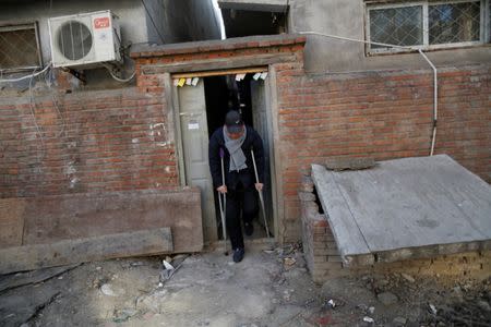 Yuan Yunping, who has melanoma of the foot, leaves the accommodation where some patients and their family members stay while seeking medical treatment in Beijing, China, January 13, 2016. REUTERS/Kim Kyung-Hoon