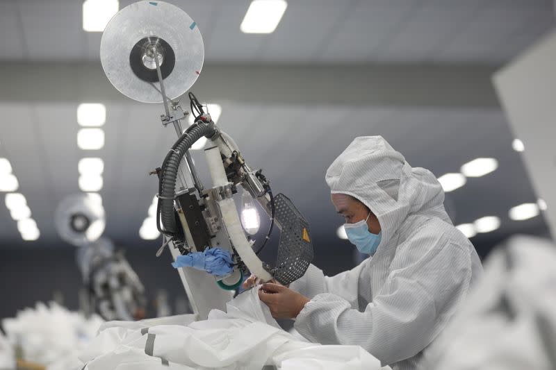 Employee works on a production line manufacturing protective suits at a medical supply factory in Xinzhou district of Wuhan