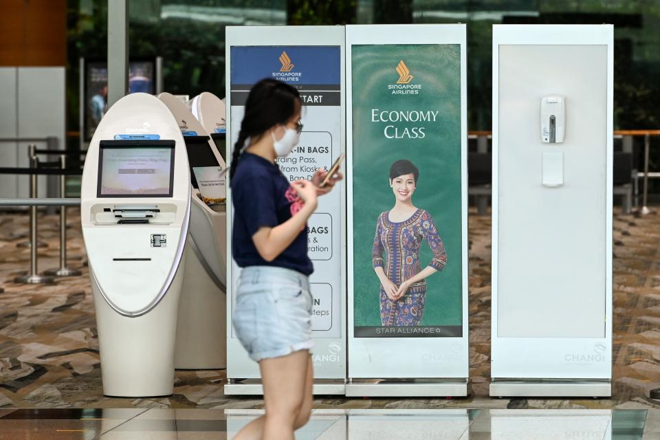 A woman walks past a Singapore Airlines check-in counter at a Changi International Airport terminal in Singapore on September 11, 2020. - Singapore Airlines said on September 10 it was cutting about 4,300 jobs -- around 20 percent of its workforce -- due to the coronavirus, and warned any recovery would be "long and fraught with uncertainty". (Photo by Roslan RAHMAN / AFP) (Photo by ROSLAN RAHMAN/AFP via Getty Images)