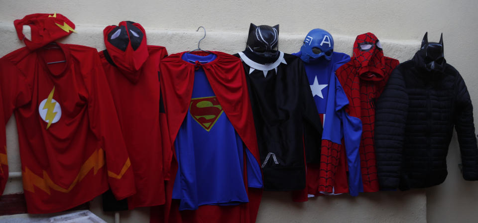 The superhero costumes that teacher Jorge Manolo Villarroel uses to impart online classes from his home, hang on a wall amid the new coronavirus pandemic in La Paz, Bolivia, Wednesday, June 10, 2020. Sometimes Villarroel is Spiderman. Sometimes, he's the Flash, or the Green Lantern. But he's always a teacher, one who lives out his childhood dreams by dressing up as a superhero for the locked-down students who attend his virtual classes. (AP Photo/Juan Karita)