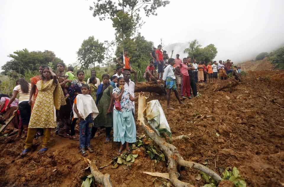 Villagers gather at the site of a landslide at the Koslanda tea plantation near Haldummulla