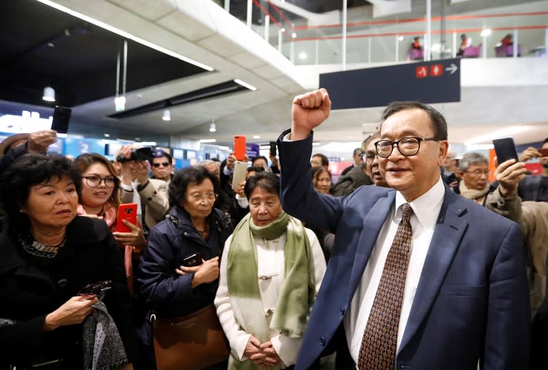 Cambodia's self-exiled opposition party founder Sam Rainsy, who has vowed to return to his home country, gestures to supporters after being prevented from checking-in for a flight from Paris to Bangkok at Roissy Airport in Paris