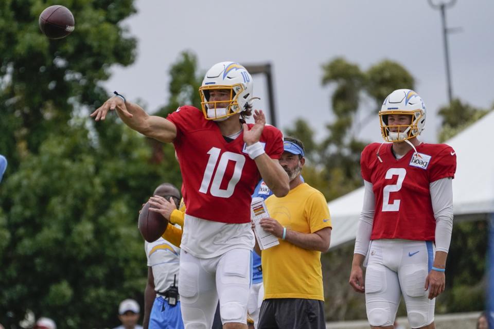 Chargers quarterback Justin Herbert throws the ball while backup Easton Stick watches during practice.