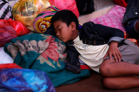 A boy that evacuated a village located along the slopes of Mount Agung, a day after the volcano's alert status was raised to the highest level, rests at a temporary shelter in Rendang, on the resort island of Bali, Indonesia September 23, 2017. REUTERS/Darren Whiteside