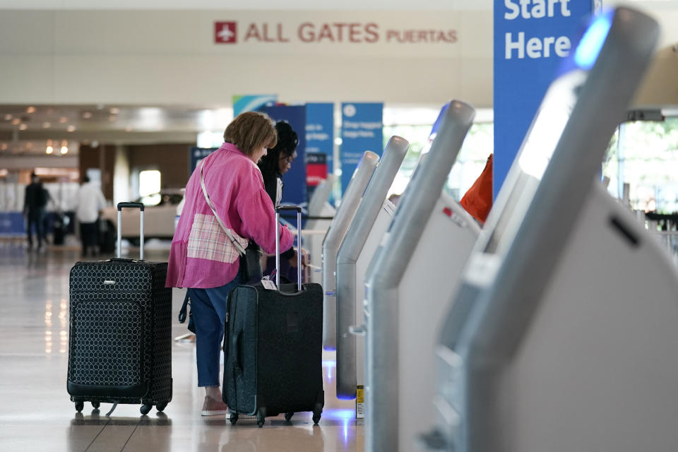 Travelers use the kiosk by the ticketing gate as they prepare for travel from Love Field airport, Friday, May 19, 2023, in Dallas. The unofficial start of the summer travel season is here, with airlines hoping to avoid the chaos of last year and travelers scrounging for ways to save a few bucks on pricey airfares and hotel rooms. (AP Photo/Tony Gutierrez)