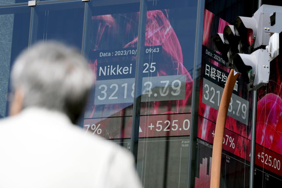 A person stands in front of an electronic stock board showing Japan's Nikkei 225 index at a securities firm Tuesday, Oct. 17, 2023, in Tokyo. (AP Photo/Eugene Hoshiko)