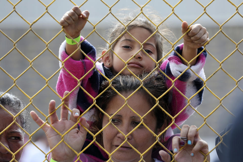 Six-year-old Daniela Fernanda Portillo Burgos sits on the shoulders of her mother, Iris Jamilet, 39, as they look out through the fence of a immigrant shelter in Piedras Negras, Mexico, Tuesday, Feb. 5, 2019. A caravan of about 1,600 Central American migrants camped Tuesday in the Mexican border city of Piedras Negras, just west of Eagle Pass, Texas. The governor of the northern state of Coahuila described the migrants as "asylum seekers," suggesting all had express intentions of surrendering to U.S. authorities. (Jerry Lara/The San Antonio Express-News via AP)