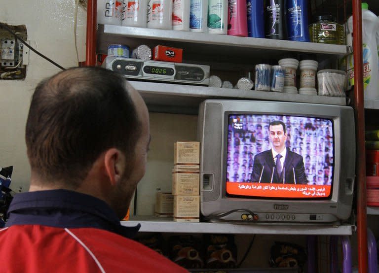 A man watches Syria's embattled President Bashar al-Assad making a public address on the state-run Syrian TV in Damascus on January 6, 2013. Bashar al-Assad in a rare speech Sunday denounced the opposition as "slaves" of the West and called for a national dialogue conference to be followed by a referendum on a national charter and parliamentary elections