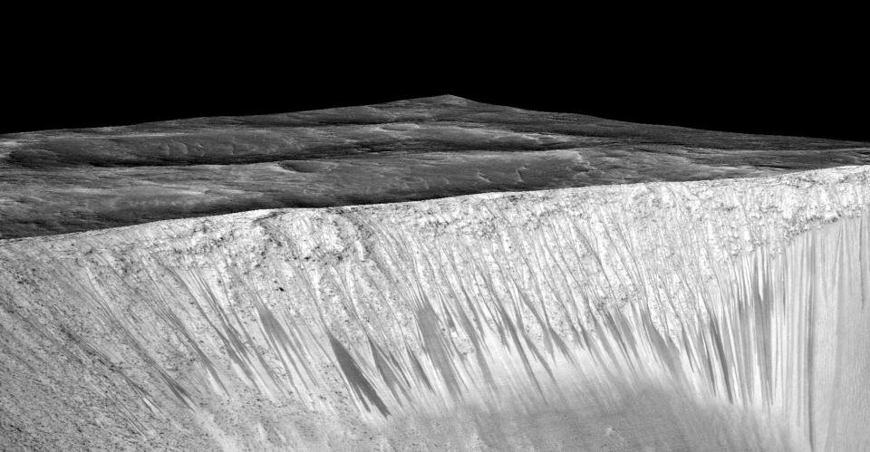 Narrow streaks on the slopes of Garni Crater are inferred to be formed by seasonal flow of water on surface of present-day Mars. (NASA)