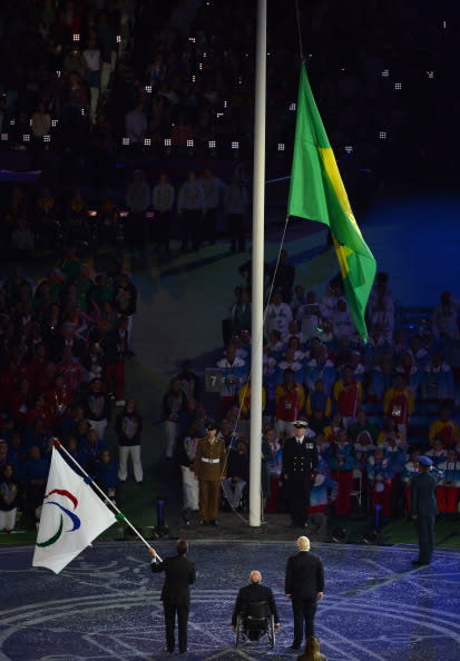 Mayor of Rio de Janeiro Eduardo Paes holds the Paralympic flag as he (L), London Mayor Boris Johnson (R) and President of the International Paralympic Committee (IPC) Philip Craven (C) watch the raising of the Brazilian flag during the closing ceremony of the London 2012 Paralympic Games at the Olympic Stadium in east London on September 9, 2012. AFP PHOTO / BEN STANSALL (Photo credit should read BEN STANSALL/AFP/GettyImages)