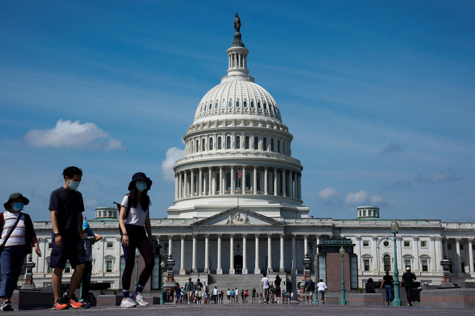 Mae pobl sy'n gwisgo masgiau i'w hamddiffyn rhag y clefyd coronafirws (COVID-19) yn cerdded heibio Capitol yr UD yn Washington, UD, Medi 4, 2022. REUTERS / Elizabeth Frantz