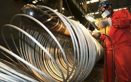 A worker polishes steel coils at a factory of Dongbei Special Steel Group Co., Ltd., in Dalian, Liaoning province, China, September 1, 2015. REUTERS/China Daily