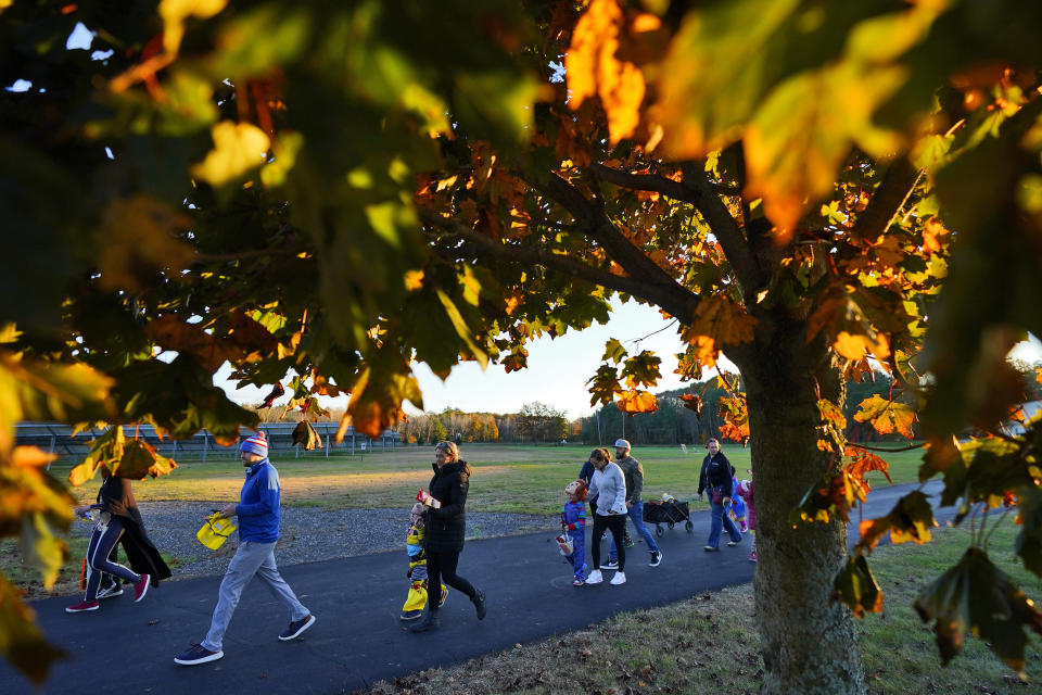 Parents and children leave after receiving free Halloween candy from a local businessman, Tuesday, Oct. 31, 2023, in Lewiston, Maine. Locals seek a return to normalcy after a shooting that claimed 18 lives in their community on Oct. 25. (AP Photo/Matt York)