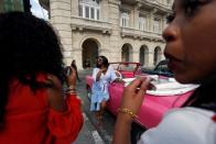 Turistas estadounidenses se toman fotografías cerca de un auto en La Habana, Cuba, 16 de julio de 2018. REUTERS/Stringer