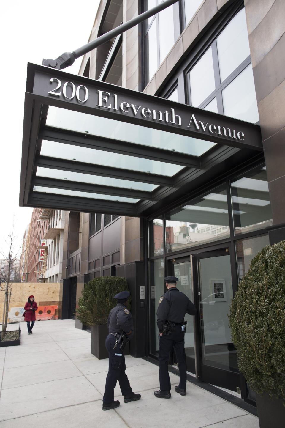 Police officers stand outside the building where the body of fashion designer L'Wren Scott was found, Monday, March 17, 2014, in New York. Scott, who was musician Mick Jagger's girlfriend, was found dead of a possible suicide, a law enforcement official said Monday. (AP Photo/John Minchillo)