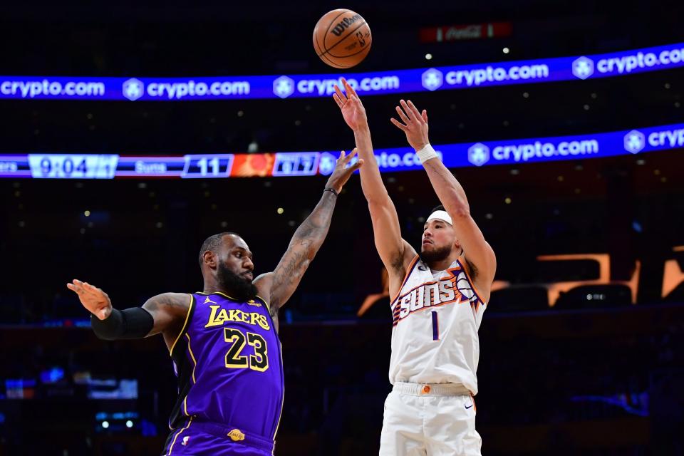 Phoenix Suns guard Devin Booker (1) shoots against Los Angeles Lakers forward LeBron James (23) during the first half at Crypto.com Arena.