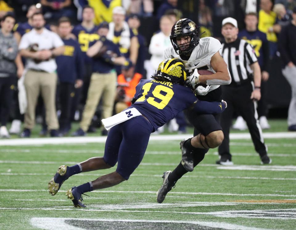 Michigan Wolverines defensive back Rod Moore (19) tackles Purdue Boilermakers running back Devin Mockobee (45) during second half action of the Big Ten Championship game at Lucas Oil Stadium in Indianapolis Saturday, December 03, 2022.