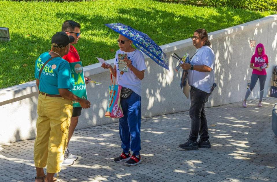 Campaign workers hand out flyers to Caridad Gonzalez Stokes (center) as she arrives to vote at Miami Beach City Hall on Oct. 31, 2023.